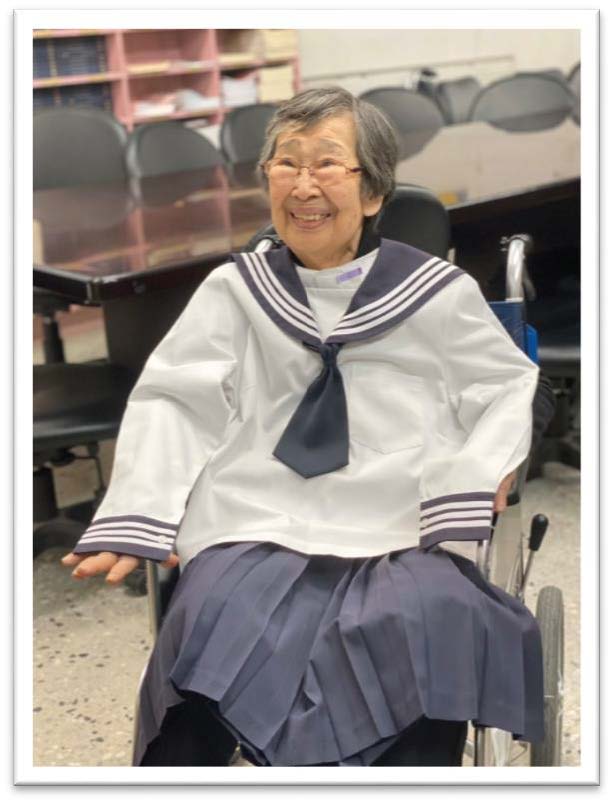 披上當年的校服，露出喜悅的笑容與善方正夫校長照片合影